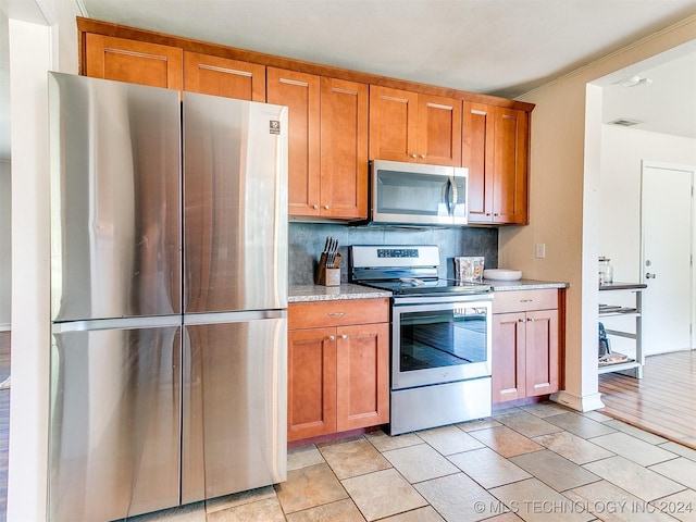 kitchen with decorative backsplash, light hardwood / wood-style flooring, and stainless steel appliances