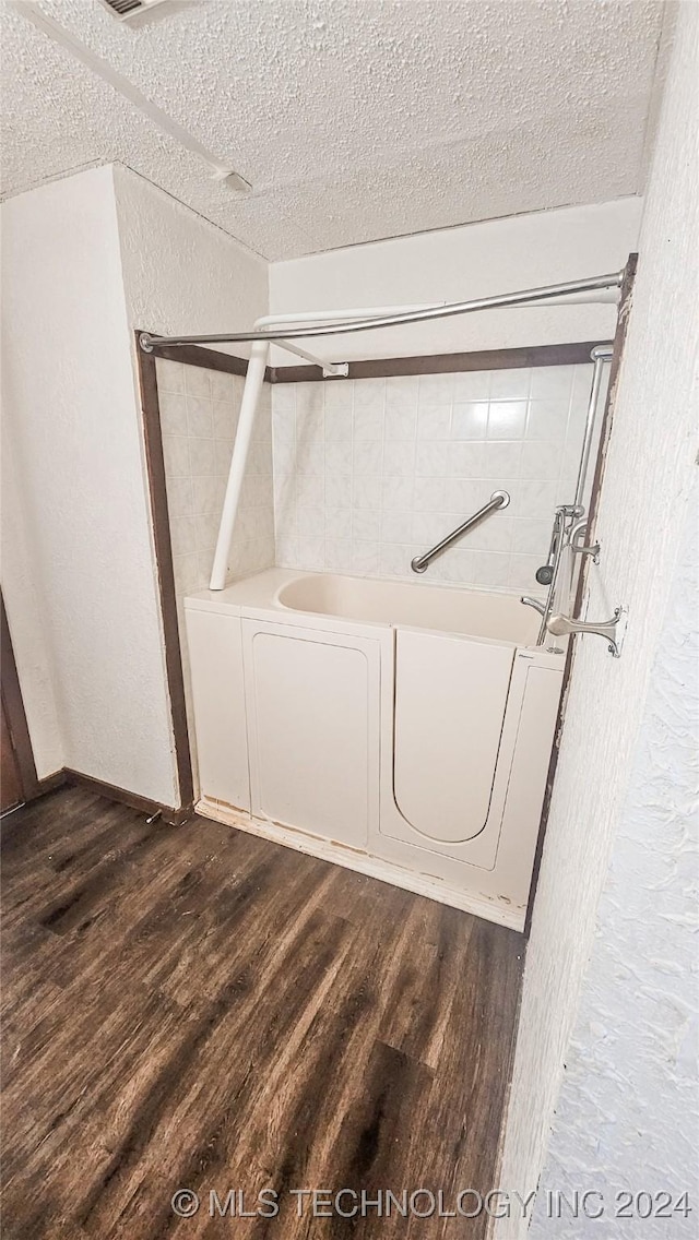 washroom featuring dark hardwood / wood-style flooring and a textured ceiling