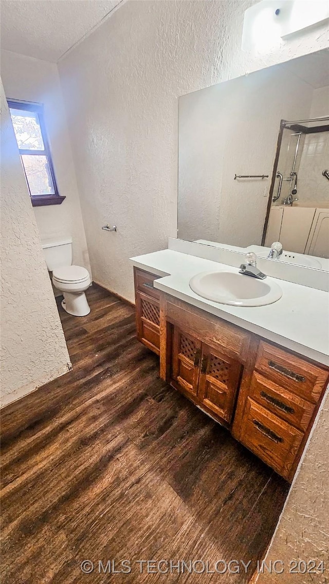 bathroom with vanity, hardwood / wood-style floors, a textured ceiling, and toilet