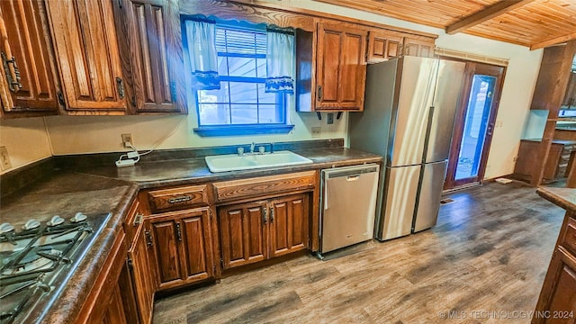 kitchen with stainless steel appliances, sink, hardwood / wood-style floors, and wooden ceiling