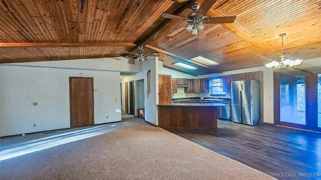 kitchen with stainless steel fridge, vaulted ceiling with beams, a healthy amount of sunlight, ceiling fan with notable chandelier, and kitchen peninsula