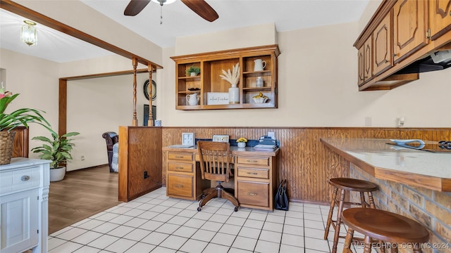 office area with wood walls, ceiling fan, and light hardwood / wood-style floors