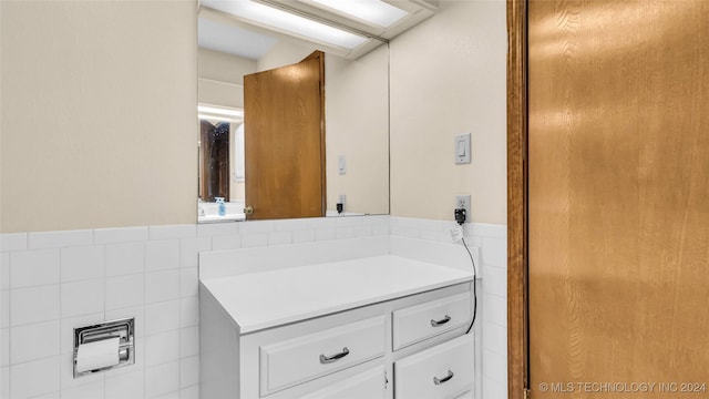 bathroom featuring vanity and tile walls