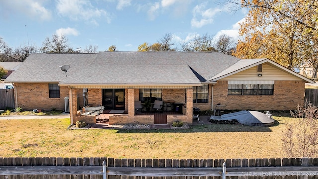 rear view of property featuring a lawn and a patio area