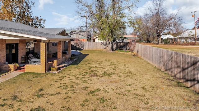 view of yard with ceiling fan and a patio