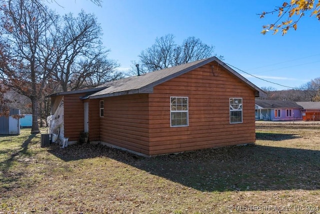 view of property exterior with a lawn and central AC unit