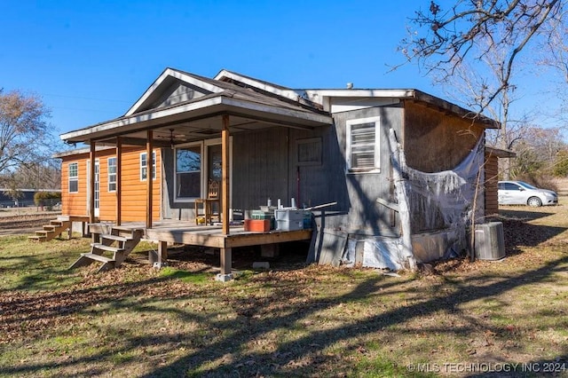 back of property with a lawn and a porch