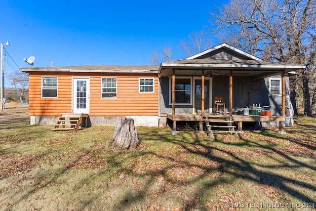 back of house with a lawn and covered porch