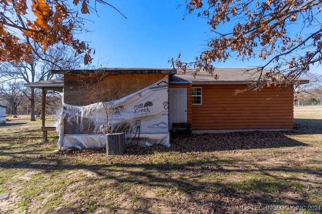 view of side of property with a lawn and central air condition unit