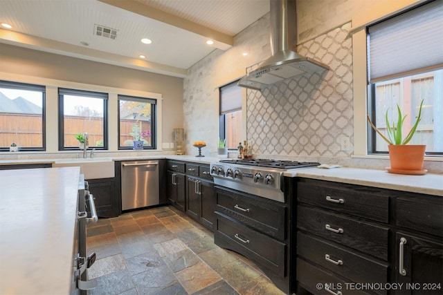 kitchen featuring appliances with stainless steel finishes, backsplash, sink, wall chimney range hood, and beamed ceiling