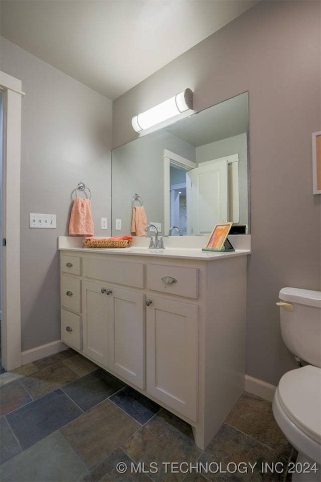 bathroom featuring vanity and toilet