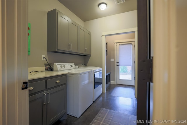 laundry area featuring washer and clothes dryer and cabinets