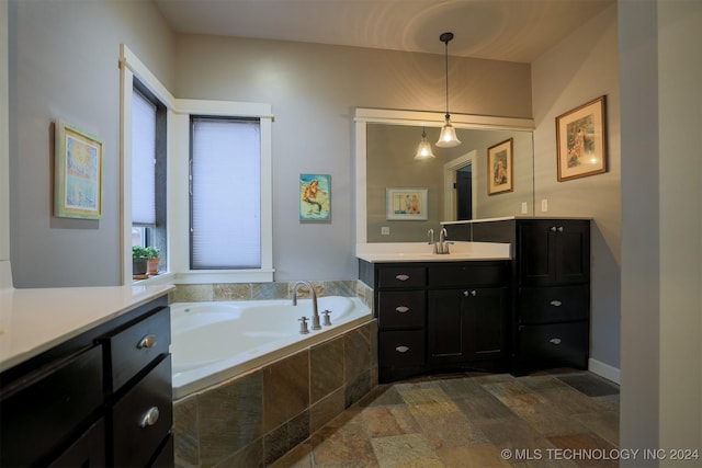 bathroom featuring vanity and a relaxing tiled tub