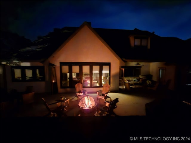 back house at twilight featuring an outdoor fire pit