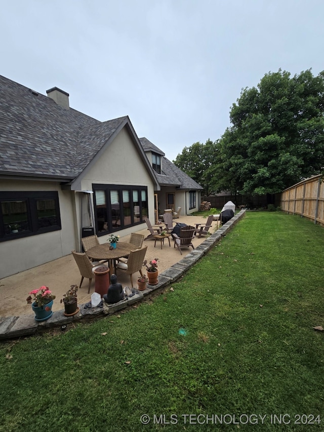 rear view of property with a patio area and a yard