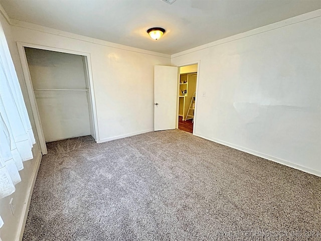 unfurnished bedroom featuring carpet flooring and a closet