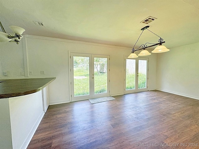 unfurnished dining area featuring french doors, a wealth of natural light, and dark wood-type flooring