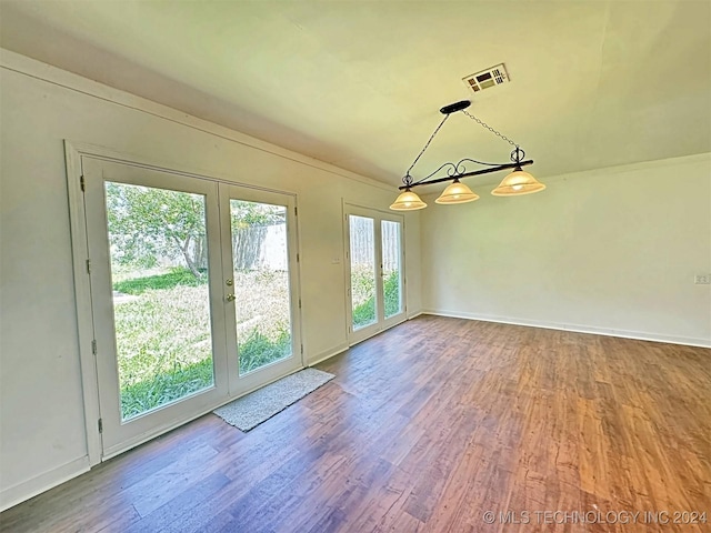 unfurnished dining area featuring wood-type flooring and french doors