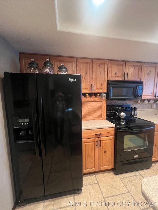 kitchen featuring tasteful backsplash and black appliances