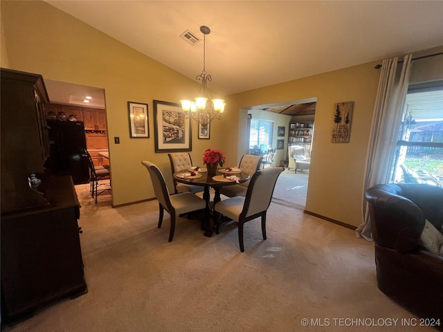 dining space with a chandelier, light colored carpet, and vaulted ceiling