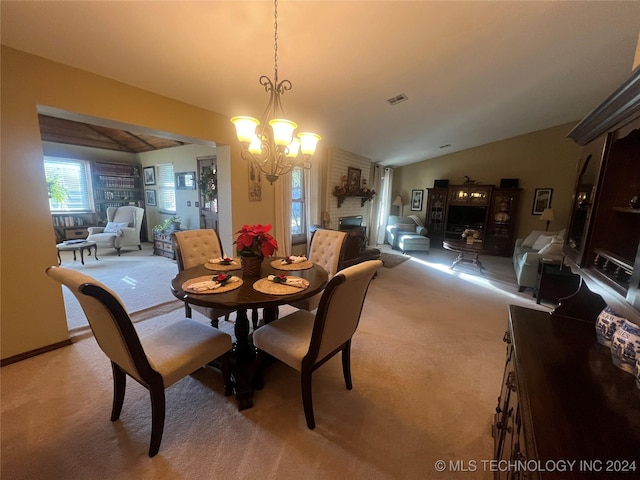 carpeted dining area featuring a notable chandelier, a large fireplace, and lofted ceiling