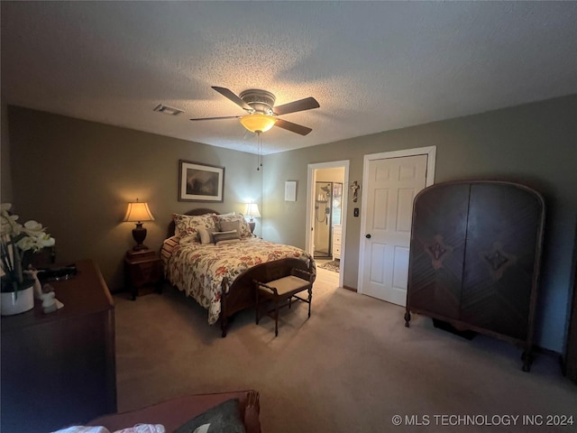 bedroom featuring ceiling fan, light colored carpet, and a textured ceiling