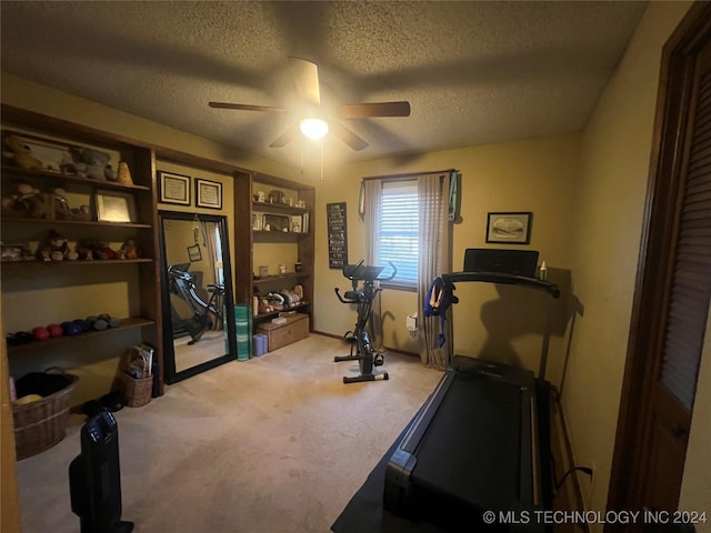 exercise room featuring light carpet, ceiling fan, and a textured ceiling