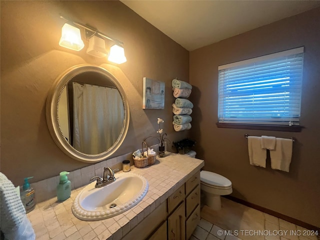 bathroom featuring tile patterned floors, vanity, and toilet