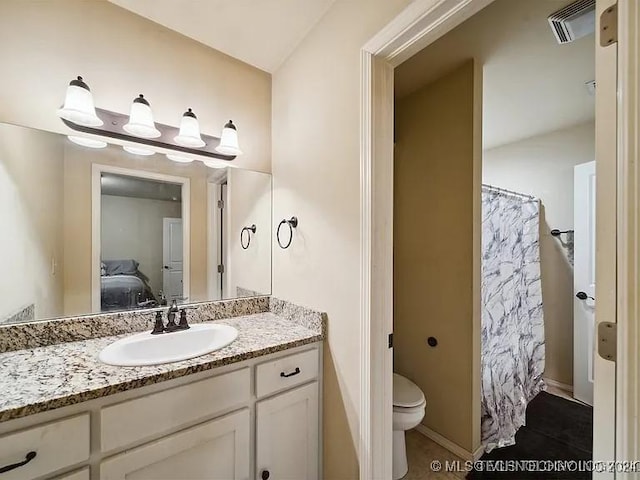 bathroom featuring vanity, toilet, and walk in shower