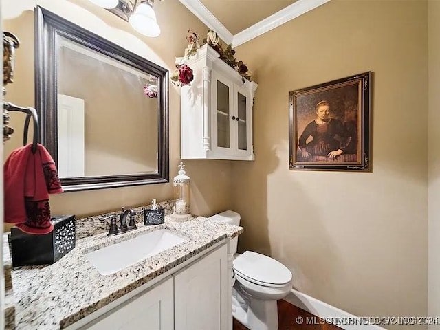 bathroom with vanity, toilet, and crown molding