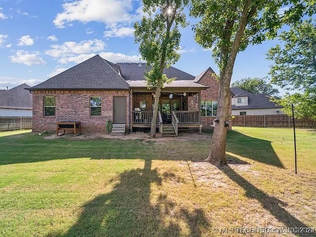 rear view of property featuring a lawn