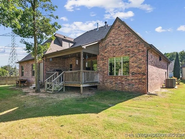 back of property with a yard and central AC