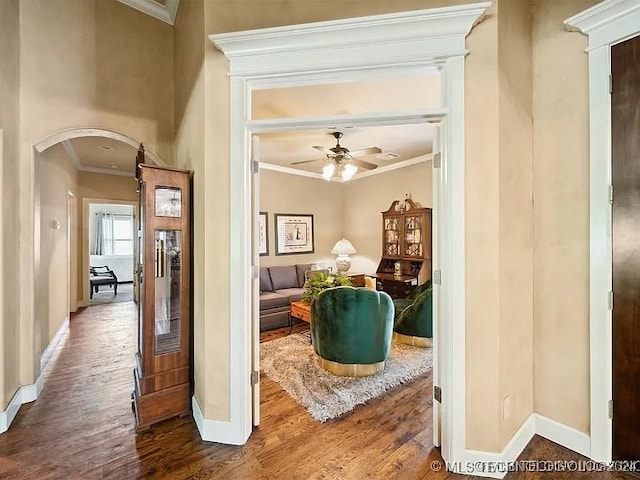 interior space featuring ceiling fan, wood-type flooring, and ornamental molding