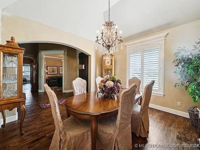 dining area with dark hardwood / wood-style floors and an inviting chandelier