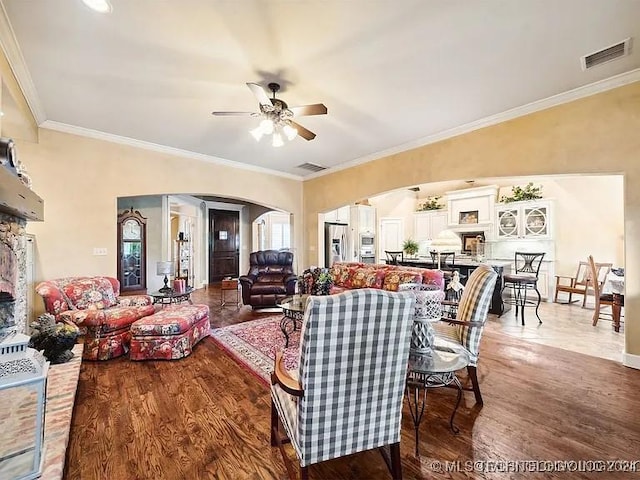 living room with hardwood / wood-style flooring, ceiling fan, and crown molding