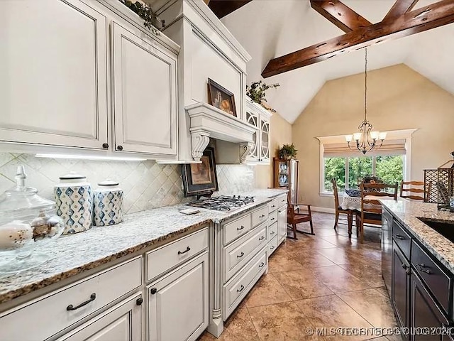 kitchen featuring appliances with stainless steel finishes, backsplash, light stone counters, decorative light fixtures, and a notable chandelier