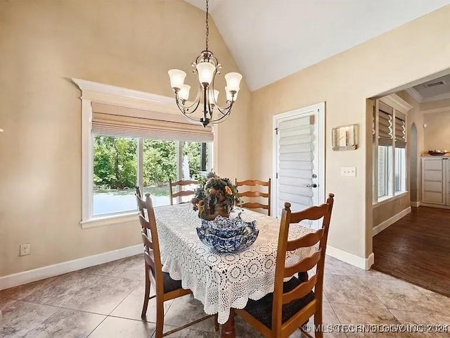 dining room with hardwood / wood-style floors, an inviting chandelier, lofted ceiling, and ornamental molding