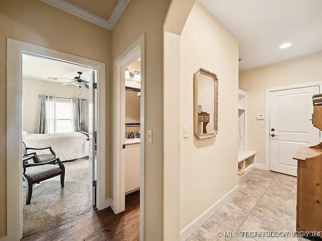 hallway featuring light hardwood / wood-style floors and ornamental molding