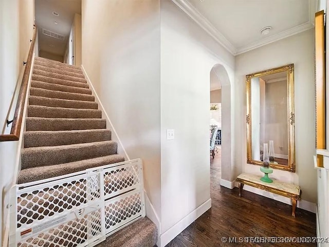 stairway featuring hardwood / wood-style floors and crown molding