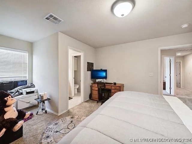 bedroom featuring light carpet and ensuite bath