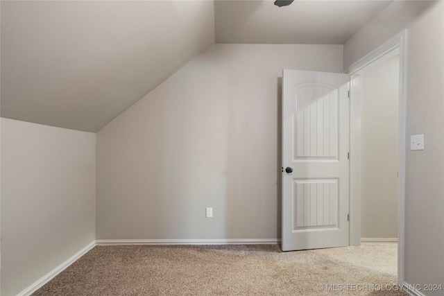 additional living space with carpet floors and vaulted ceiling