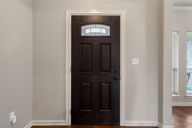 entryway featuring hardwood / wood-style floors and crown molding