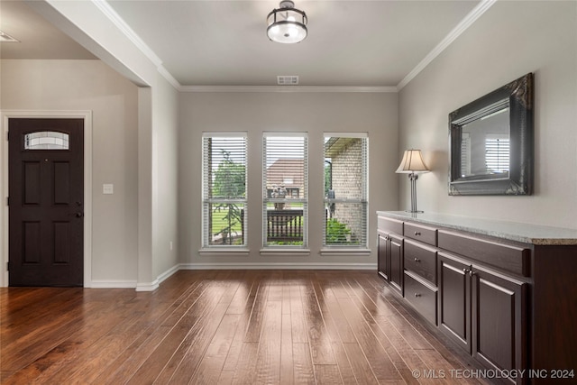 foyer entrance with crown molding and dark hardwood / wood-style floors