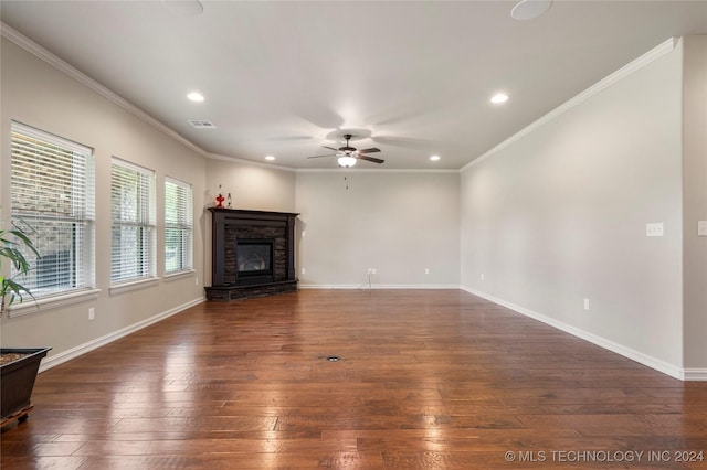 unfurnished living room with dark hardwood / wood-style floors, ceiling fan, a stone fireplace, and crown molding