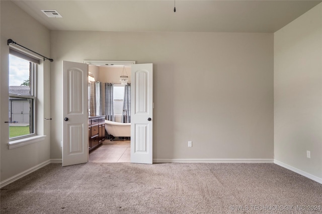 unfurnished bedroom with light carpet and multiple windows