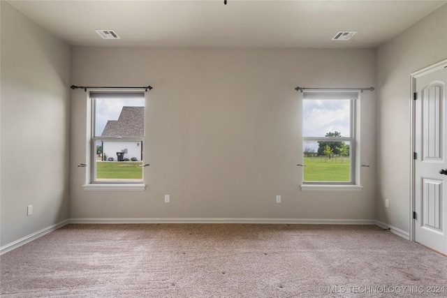 spare room featuring light colored carpet and a healthy amount of sunlight