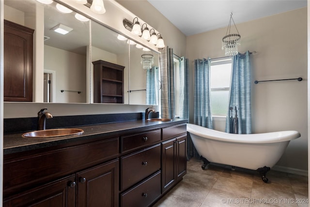 bathroom with a bathing tub, tile patterned flooring, vanity, and an inviting chandelier