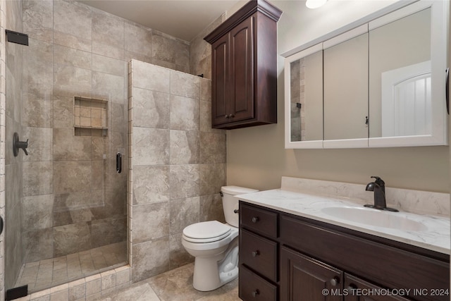 bathroom featuring tile patterned floors, toilet, vanity, and walk in shower