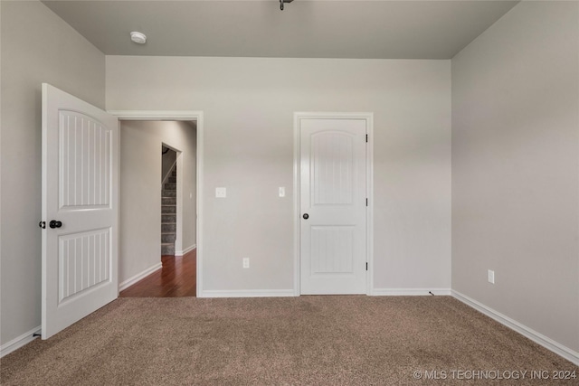 unfurnished bedroom with dark colored carpet