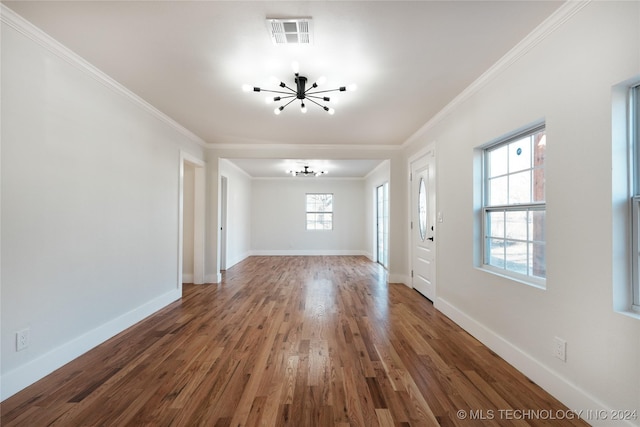 interior space with dark hardwood / wood-style floors, an inviting chandelier, and crown molding